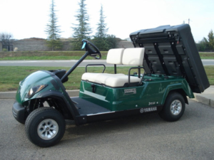 Yamaha utility golf car in the color green with manual dump
