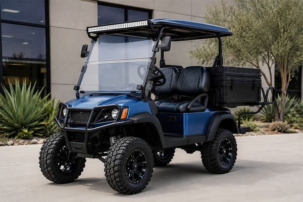 A customized golf car on display, featuring visible aftermarket upgrades including a lift kit with larger tires, a heavy-duty cargo box, and LED light bar.